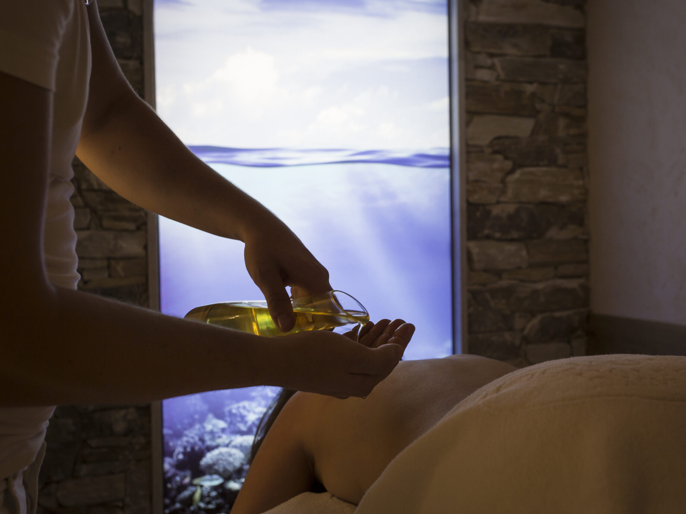 Massage mit Öl in entspannendem Spa-Ambiente