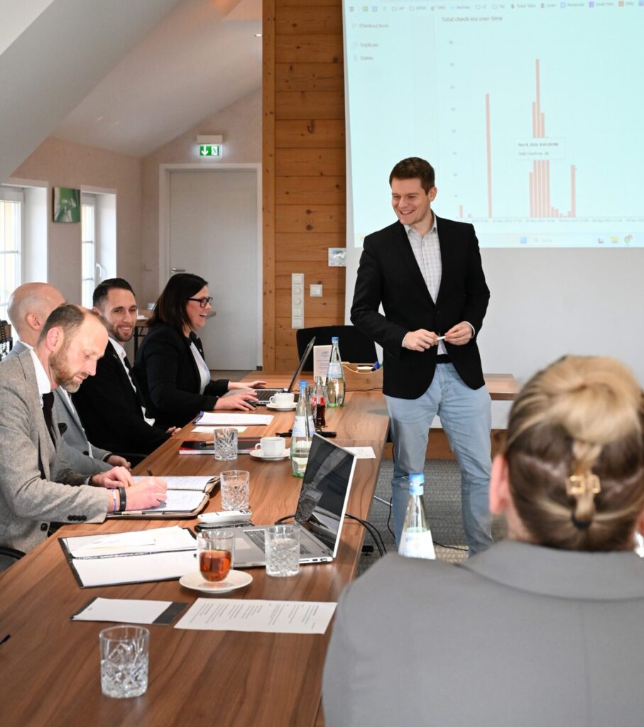 Geschäftstreffen mit Präsentation und Diskussion in Konferenzraum.