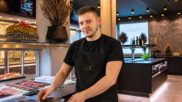Restaurantmitarbeiter stapelt Teller am Buffet