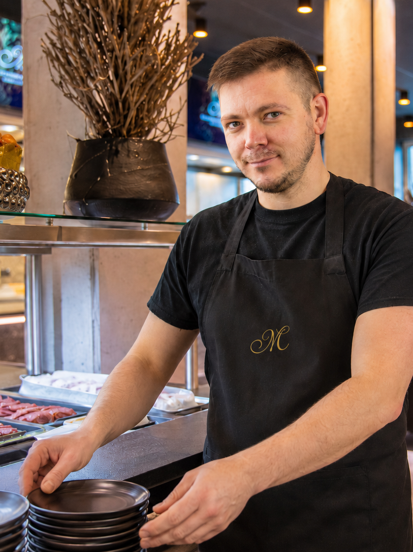 Mann mit schwarzer Schürze im Restaurant
